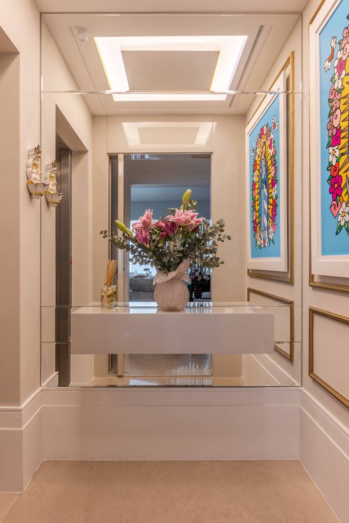 moveis-curvos-boiseries-trazem-elegancia-ape-230m-cristiane-schiavoni-02-hall-flores-espelho Hall de entrada com espelho, aparador, vaso de flores e quadro.
