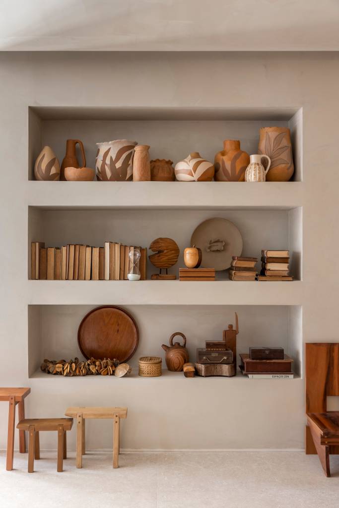 slow-living-sala-estar-refugio-materiais-naturais-artesanato-isabela-nallon-casacor-sp-2023-02 Nichos na parede com cerâmicas e outros objetos de artesanato.