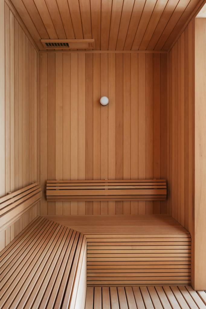 cobertura-sauna-paredes-vidro-e-area-gourmet-balancos-vivian-reimers-38 Cobertura tem sauna com paredes de vidro e área gourmet com balanços. Projeto de Vivian Reimers. Na foto, sauna revestida de madeira com banco, porta e parede de vidro.