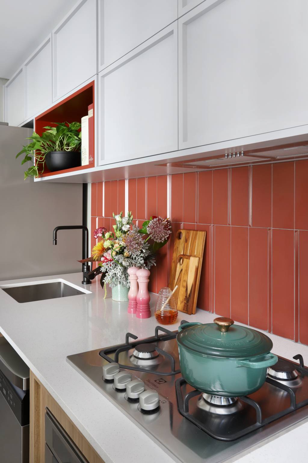 ape-de-68-m2-tem-espaco-para-chapelaria-e-painel-com-portas-mimetizadas-15-backsplash Apê de 68 m² tem espaço para chapelaria e painel com portas mimetizadas. Projeto do Studio 92 Arquitetura. Na foto, pia de cozinha com backsplash vermelho