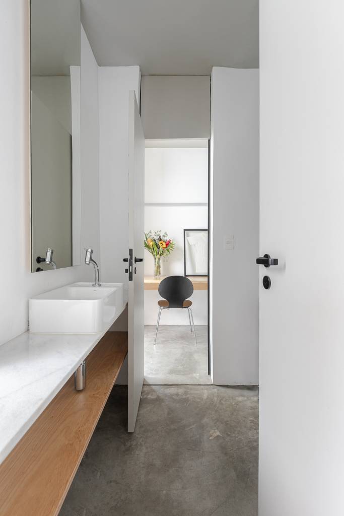 Casa tem cozinha com azulejos florais e edícula com banheiro canadense. Projeto de Pro.a Arquitetura.