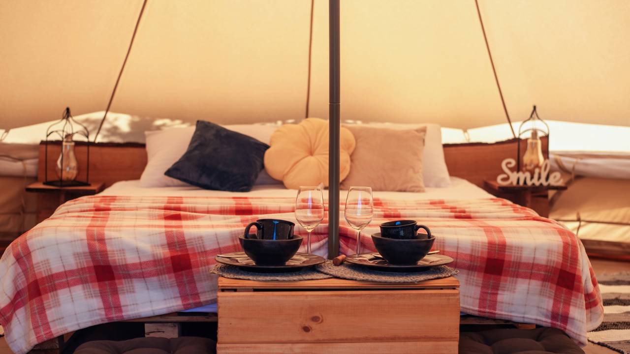 Conheça o estilo glamping que une sofisticação e conexão com a natureza. Freepix. Na foto: estilo glamping, cama feita, roupa de cama