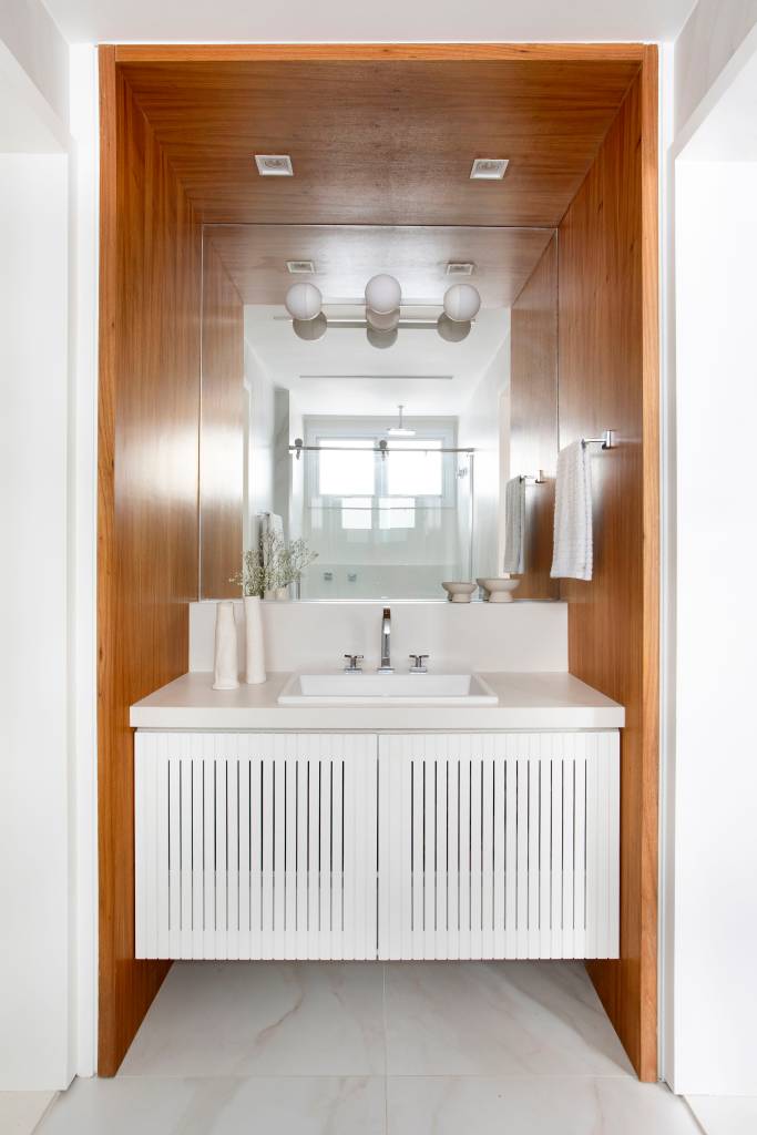 Apartamento ganha banheiro canadense e armários azuis com ar retrô na cozinha. Projeto de Bezamat Arquitetura.